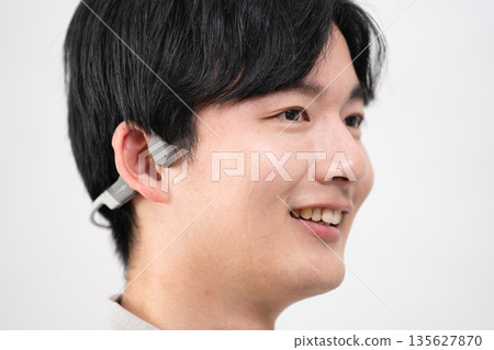 Young man listening to music with wireless earphones Young man listening to music with wireless earphones 135627870