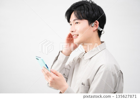 聽到與無線耳機的音樂的年輕人 135627871