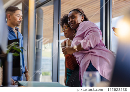 Colleagues in office sharing joyful moment during casual business meeting Colleagues in office sharing joyful moment during casual business meeting 135628288