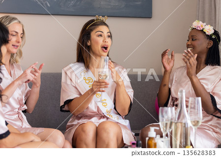 Women in robes celebrating with champagne, laughing and enjoying bachelorette party Women in robes celebrating with champagne, laughing and enjoying bachelorette party 135628383
