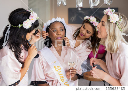 Bride-to-be enjoying bridal shower with friends helping her get ready at home Bride-to-be enjoying bridal shower with friends helping her get ready at home 135628485