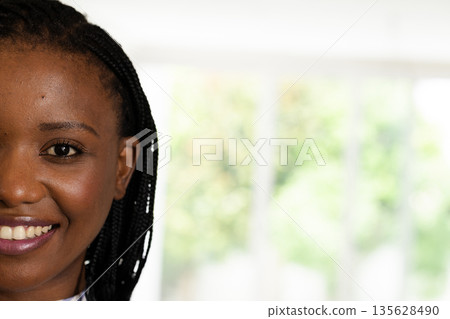 Smiling woman with braided hair enjoying bright day indoors, feeling happy 135628490