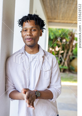 Smiling man in casual shirt standing outdoors, enjoying sunny day 135628522