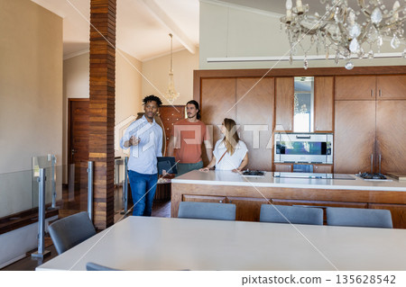 Real estate agent showing modern kitchen to couple, discussing home features 135628542