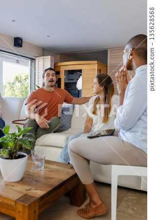 Friends discussing ideas in living room, enjoying casual conversation and connection Friends discussing ideas in living room, enjoying casual conversation and connection 135628568