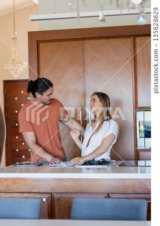 Preparing meal, couple laughing together in modern kitchen, sharing joyful moment Preparing meal, couple laughing together in modern kitchen, sharing joyful moment 135628629
