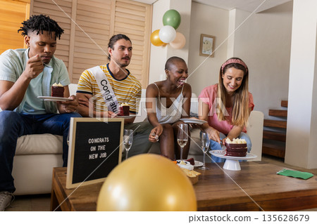 Celebrating new job, diverse friends enjoying cake and champagne at home Celebrating new job, diverse friends enjoying cake and champagne at home 135628679