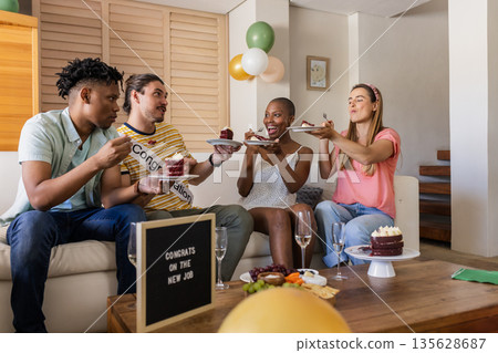 Celebrating new job, diverse friends enjoying cake and champagne at home party Celebrating new job, diverse friends enjoying cake and champagne at home party 135628687