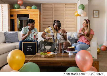 Celebrating new job, friends enjoying cake and champagne at home party 135628699