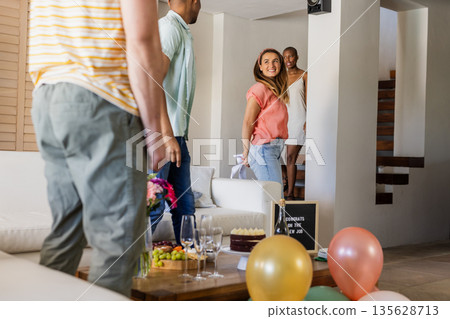 Friends celebrating new job with balloons and snacks, smiling and chatting happily Friends celebrating new job with balloons and snacks, smiling and chatting happily 135628713