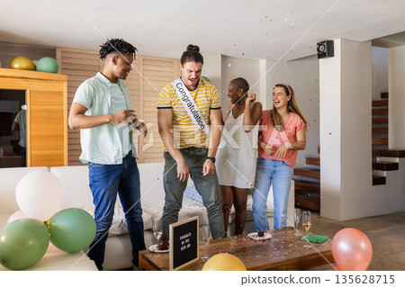 Celebrating at home, friends with balloons and confetti sharing joyful moments Celebrating at home, friends with balloons and confetti sharing joyful moments 135628715