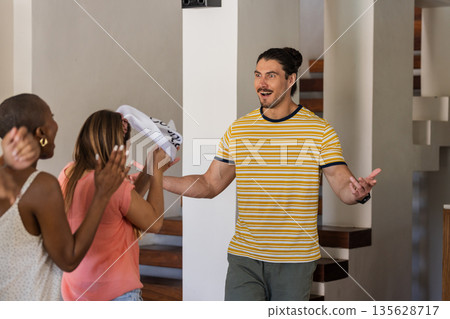 Friends welcoming guest with excitement and joy at home gathering Friends welcoming guest with excitement and joy at home gathering 135628717