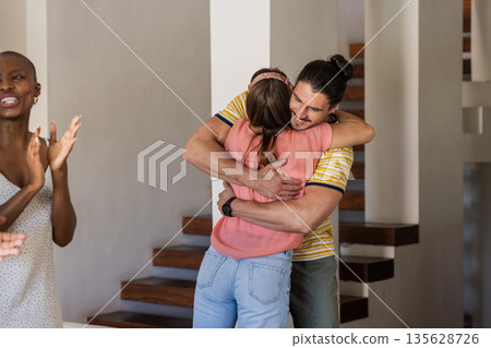 Friends hugging and celebrating at home, enjoying joyful and warm moments together Friends hugging and celebrating at home, enjoying joyful and warm moments together 135628726