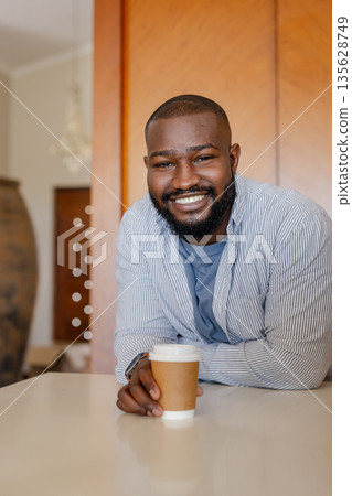 Smiling man enjoying coffee at home, leaning on kitchen counter Smiling man enjoying coffee at home, leaning on kitchen counter 135628749