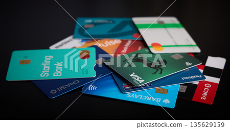 Scattered Credit and Debit Cards on Dark Background Scattered Credit and Debit Cards on Dark Background 135629159