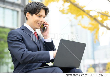 Man using laptop in office district Man using laptop in office district 135629298