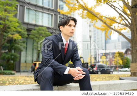 An office district with roadside trees and a man in a suit An office district with roadside trees and a man in a suit 135629430