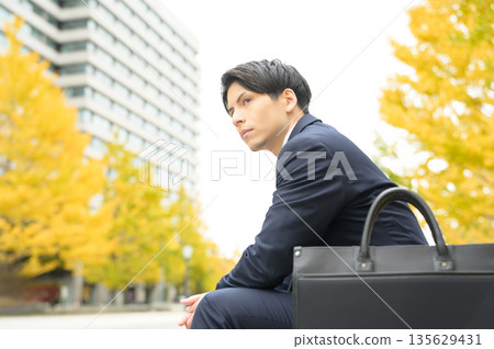 An office district with roadside trees and a man in a suit 135629431