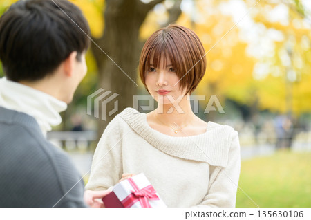 Male and female giving gifts 135630106