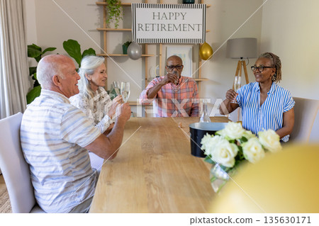 Senior friends celebrating retirement with champagne at home, smiling and toasting Senior friends celebrating retirement with champagne at home, smiling and toasting 135630171