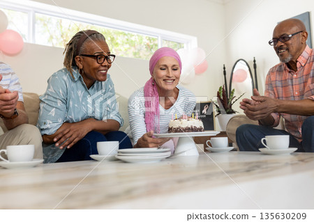 Celebrating birthday, senior friends sharing cake and tea, enjoying joyful moments together Celebrating birthday, senior friends sharing cake and tea, enjoying joyful moments together 135630209