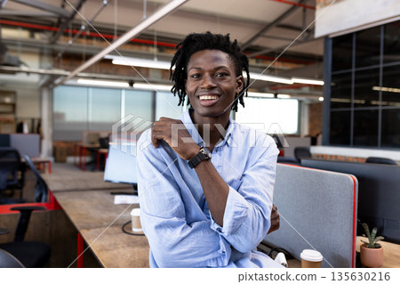 In modern office, professional embracing creative environment while smiling confidently 135630216