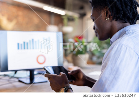 Business professional analyzing data on tablet and computer in modern office 135630247