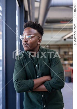 African American man in office looking out window, contemplating new ideas African American man in office looking out window, contemplating new ideas 135630289