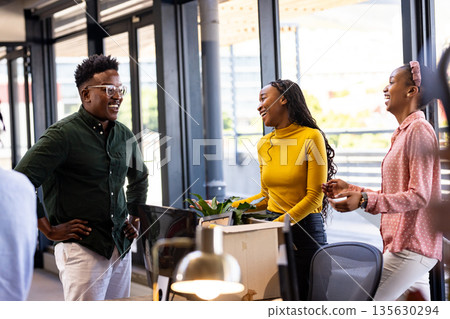 Colleagues in modern office laughing and discussing creative project together Colleagues in modern office laughing and discussing creative project together 135630294