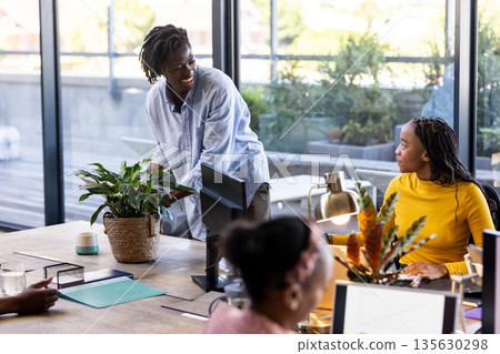 Collaborating in modern office, colleagues discussing ideas with enthusiasm and focus Collaborating in modern office, colleagues discussing ideas with enthusiasm and focus 135630298