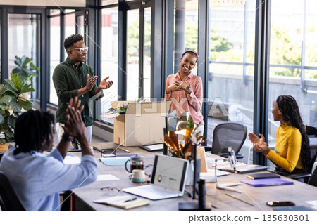 African American colleagues applauding in modern office during team celebration 135630301