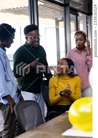 Team collaborating in modern office, smiling and discussing creative ideas together 135630324