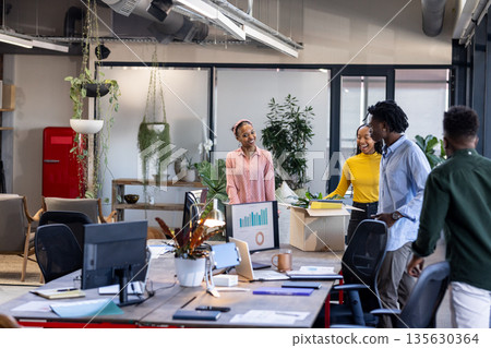 Diverse team collaborating in modern office, discussing project with enthusiasm Diverse team collaborating in modern office, discussing project with enthusiasm 135630364