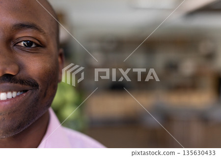 Smiling businessman in pink shirt at office, exuding confidence and positivity Smiling businessman in pink shirt at office, exuding confidence and positivity 135630433