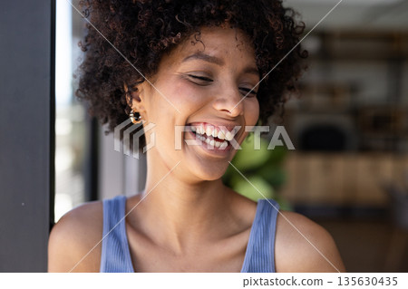 Smiling woman in blue top enjoying break at modern office 135630435