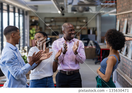 Colleagues in office clapping and celebrating success with joyful expressions 135630471