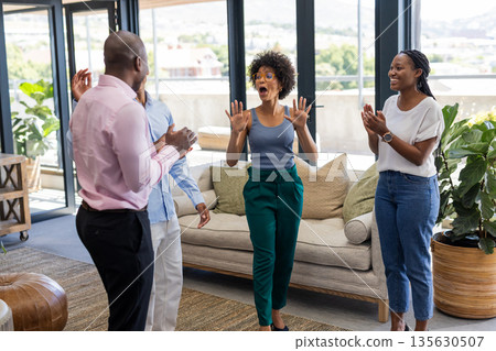 Celebrating success, colleagues expressing excitement and joy together in modern office 135630507