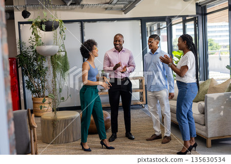 Celebrating success, colleagues in office smiling and clapping together with joy Celebrating success, colleagues in office smiling and clapping together with joy 135630534