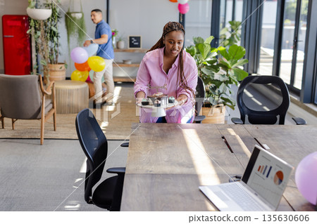 Woman in office carrying cake platter, preparing for business celebration Woman in office carrying cake platter, preparing for business celebration 135630606