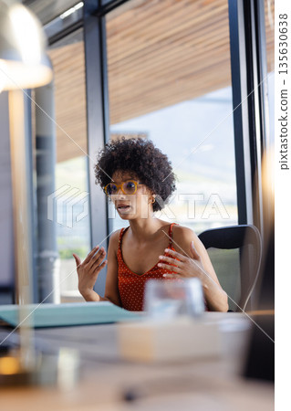 Businesswoman in office discussing ideas passionately during meeting with colleagues Businesswoman in office discussing ideas passionately during meeting with colleagues 135630638