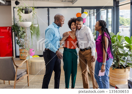 Celebrating in modern office, African American colleagues sharing joyful moment together Celebrating in modern office, African American colleagues sharing joyful moment together 135630653