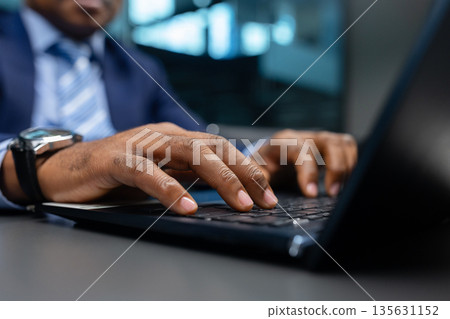 African American executive typing on laptop in contemporary office African American executive typing on laptop in contemporary office 135631152