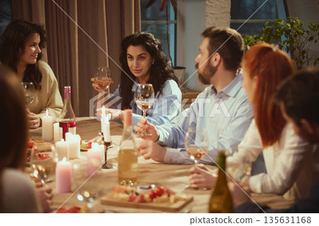 Group of friends enjoying relaxed wine dinner together. 135631168