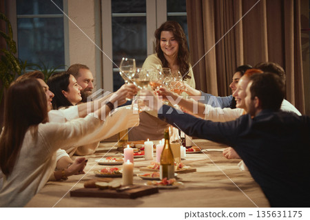 Friends in their thirties enjoying relaxed wine evening together. Friends in their thirties enjoying relaxed wine evening together. 135631175