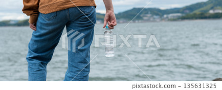 Person holding a bottle of water 135631325