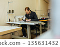 Close up of a male shoemaker working with leather textile at his workshop 135631432