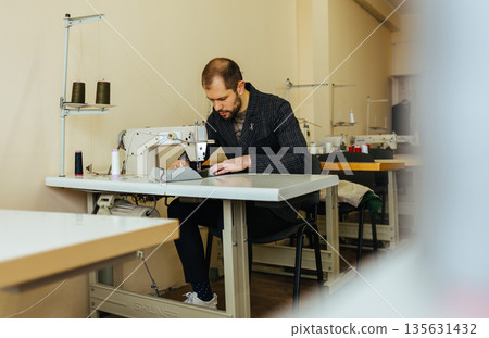 Close up of a male shoemaker working with leather textile at his workshop Close up of a male shoemaker working with leather textile at his workshop 135631432