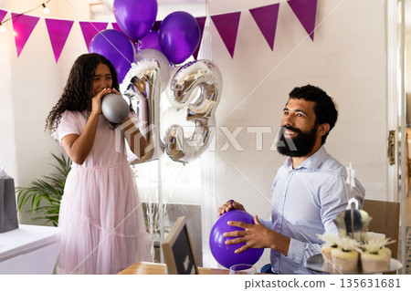 Father and daughter celebrating 13th birthday with balloons and decorations at home Father and daughter celebrating 13th birthday with balloons and decorations at home 135631681