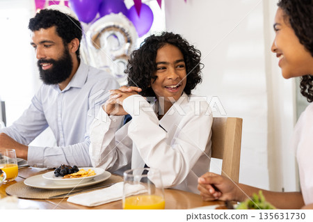 Family sharing festive meal, laughing and talking together at dining table Family sharing festive meal, laughing and talking together at dining table 135631730