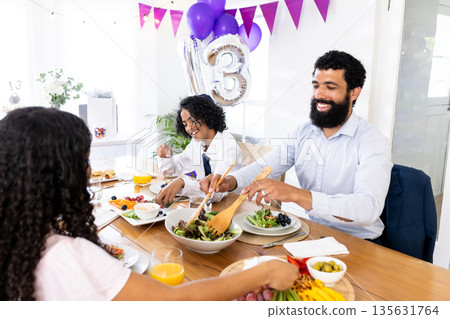 Celebrating special occasion, family sharing festive meal with joy and laughter together Celebrating special occasion, family sharing festive meal with joy and laughter together 135631764